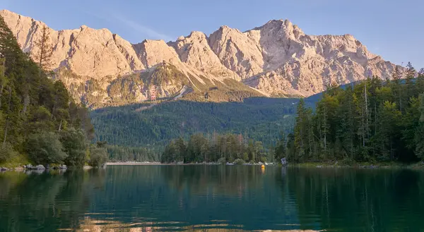 Bu nefes kesici görüntü, Eibsee 'nin dingin güzelliğini gözler önüne seriyor. Zugspitze' nin eteklerinde, Almanların en yüksek tepesinde kurulmuş bir alp gölü. Gölün berrak suları mükemmel bir şekilde yansıyor.