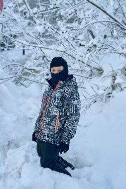 Bu büyüleyici kış sahnesinde karla kaplı bir yolda dingin bir ormanda dolanan genç bir çocuk görülüyor. Çocuk soğuk hava keşfi için siyah beyaz bir kamuflajla giyinmiş.