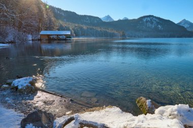 Huzurlu Kış Harikalar Diyarı: Donmuş Göl, Karla kaplı dağları yansıtıyor Altın Sabah Işıl ışıl buzlu manzaralar Kıtır Güneşli bir günde Alp Gölü 'nün nefes kesici güzelliğini yakalıyor