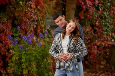 Genç Sevimli Kadın Hugs erkek. Sonbahar açık. Lovers Park'ta yürüyordunuz. Çekici komik çift. Ormandaki lovestory. Erkek ve kadın. Parkta şirin severler. Aile kavramı. Mutlu çift.