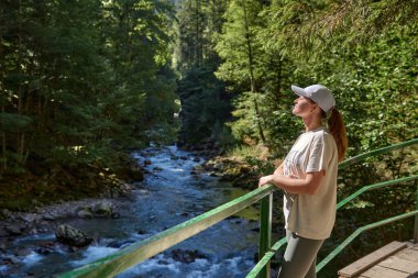 Yazın Alplerde Yürüyüş Yolu 'nda Manzaralı Dağ Nehri Manzarası İzleyen Çarpıcı Genç Kadın. Idyllic Alpine Manzarası Açık Hava Macerası ve Doğal Güzelliğin Özünü Yakalıyor. Bu...