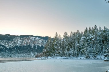 Büyüleyici Alacakaranlık Alp Harikalar Diyarı: Eibsee Gölü Kar Kaplamalı Zugspitze Dağı 'nı Aydınlatılmış Çam Ormanı' nın ortasında Yansıtır Kış Büyüleyici Manzarası Alman Kayak Resimlerinin Huzurlu Güzelliğini Yakalar