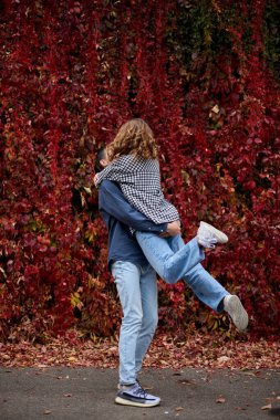 Genç Sevimli Kadın Hugs erkek. Sonbahar açık. Lovers Park'ta yürüyordunuz. Çekici komik çift. Ormandaki lovestory. Erkek ve kadın. Parkta şirin severler. Aile kavramı. Mutlu çift.