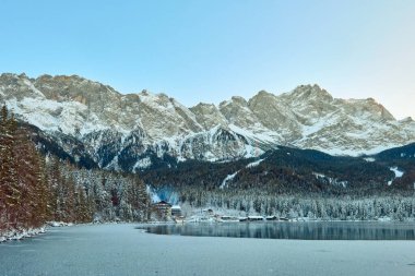 Görkemli Donmuş Eibsee Gölü, Buzlu Dağ Tepelerini Yansıtır Sabah Sabah Sabah Aydınlığı Altında Saf Kış Harikalar Diyarı Arkaplanda Karla Kaplanmış Zugspitze ile Doğayı Huzurlandırır. Bu nefes kesici görüntü donuk Eibsee Gölü 'nü sergiliyor.