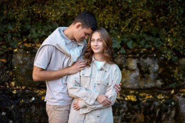 Genç Sevimli Kadın Hugs erkek. Sonbahar açık. Lovers Park'ta yürüyordunuz. Çekici komik çift. Ormandaki lovestory. Erkek ve kadın. Parkta şirin severler. Aile kavramı. Mutlu çift.