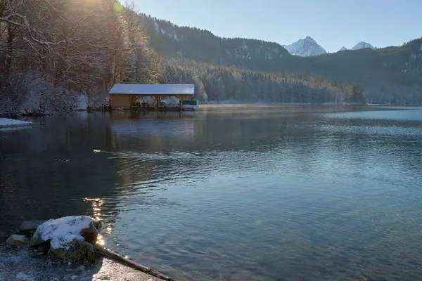 Huzurlu Kış Harikalar Diyarı: Donmuş Göl, Altın Sabah Donmuş Dağları Yansıtır. Buz gibi buzlu manzaralar, Kıtır Güneşli bir günde Alp Gölü 'nün nefes kesici güzelliğini yakalar. Bu büyüleyici görüntü, sakin bir kış manzarasını gözler önüne serer.