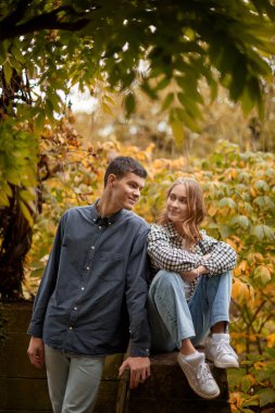 Genç Sevimli Kadın Hugs erkek. Sonbahar açık. Lovers Park'ta yürüyordunuz. Çekici komik çift. Ormandaki lovestory. Erkek ve kadın. Parkta şirin severler. Aile kavramı. Mutlu çift.