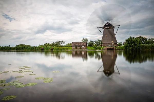 Anaokulundaki bir kanalın rüzgar gülü. Yakınındaki küçük ev suya uzun süre yansıyor.