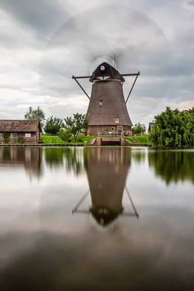 Anaokulundaki bir kanalın rüzgar gülü. Yakınındaki küçük ev suya uzun süre yansıyor.