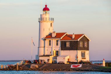 paard van marken lighthouse on marken island in golden hour with blue sky and sea