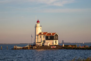 paard van marken lighthouse on marken island in golden hour with blue sky and sea
