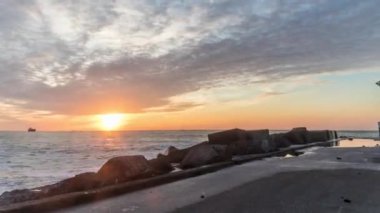 sunset timelapse at zuidpier Ijmuiden lighthouse in netherlands at the sea ship passing by