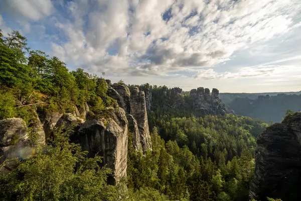 Bastei Köprüsü, Almanya 'nın Saksonya kentindeki engebeli uçurumları ve yemyeşil yeşillikleri aydınlatan Elbe Sandstone Dağları' nın gün doğumunda nefes kesici manzarasını sunuyor. Doğanın güzelliği gözlemciyi cezbeder..