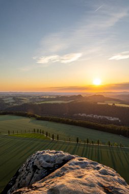 Sakson İsviçre 'deki Lilienstein zirvesinden nefes kesici gün batımı güzel Elbe Kum Taşı Dağları' nı ve renkli gökyüzünün altında akan yeşil tarlaları sergiliyor..
