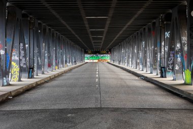 Uzun bir bakış açısı, Almanya 'nın Hamburg kentindeki çağdaş bir üst geçidin altında sütunlarında renkli sokak sanatlarıyla süslenmiş ıssız bir yolun yaratıcılık için kentsel bir tuval oluşturduğunu gösteriyor..