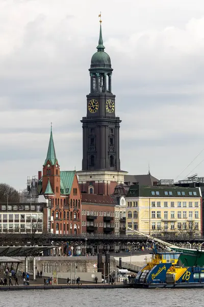 Şehrin üzerinde yükselen St. Michael Kilisesi, Hamburg 'un ufuk çizgisinde belirgin bir şekilde duruyor ve liman dolup taşıyor. Tarihi ve modern binaların karışımı büyüleyici bir manzara yaratır..