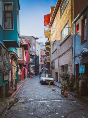 İstanbul Balat sokağındaki dar kaldırım taşları renkli evlerin ve park halindeki eski arabaların yanından geçiyor, balkonlar, bitkiler ve şehir cazibesiyle dolu sakin bir bölgede..