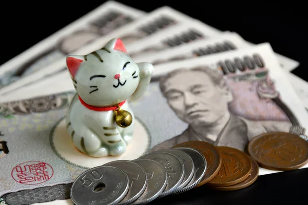 暗い背景で招き猫と日本のお金の小さな手作り陶器の閉鎖 — ストック写真