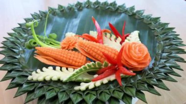 Tayland sebze oyması birçok çeşit sebze içerir, birçok renk, güzelce düzenlenmiştir. Muz yapraklarından yapılmış doğal bir tabağa yerleştirilmiş.. 