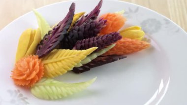 Tayland sebze oyması birçok çeşit sebze içerir, birçok renk, güzelce düzenlenmiştir. Beyaz bir seramik tabağa yerleştirilmiş..