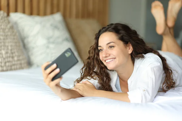 Щаслива Жінка Лежить Ліжку Приймаючи Селфі Або Записуючи Відео Телефоном — стокове фото
