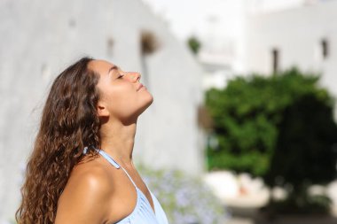 Yazın şehirde temiz hava soluyan bir kadının portresi.