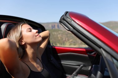 Üstü açık bir arabada dinlenen rahat sürücü.