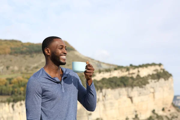 快乐的黑人喝咖啡 凝视着山中的风景 — 图库照片