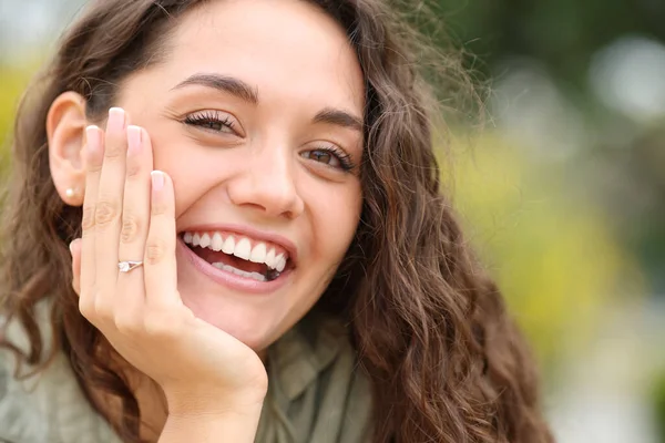 幸せな女性笑顔でカメラショー婚約指輪で公園 — ストック写真