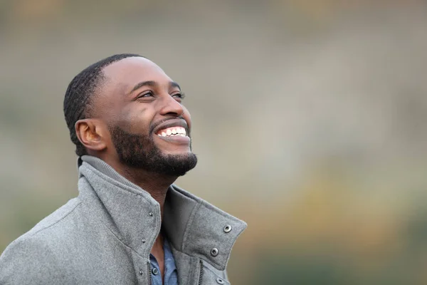 快乐的黑人男人笑着抬头望着冬天的室外 — 图库照片