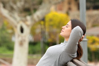 Bankta rahatlayan bir kadının yan görünümü