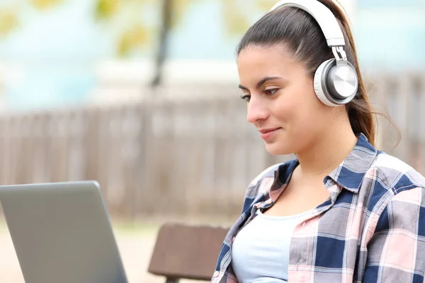 Adolescente Usando Fones Ouvido Assistindo Vídeos Laptop Banco — Fotografia de Stock