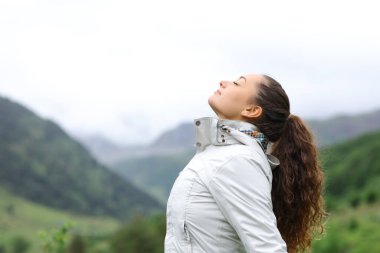 Profile of a hiker breathing fresh air in nature