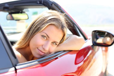 Satisfied driver in a convertible car looking at camera