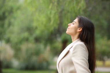 Side view portrait of a woman breathing in a park in winter