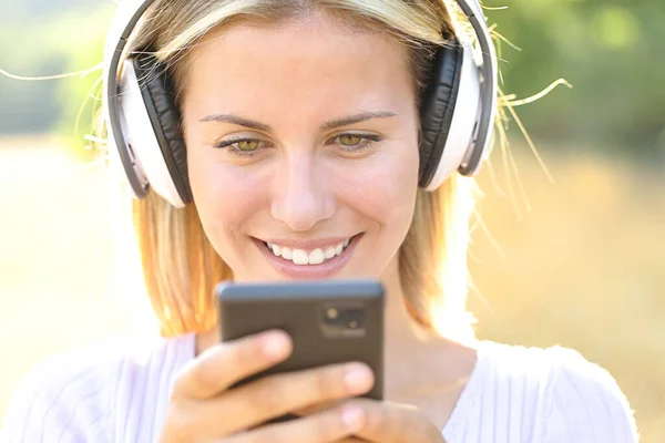 Widok Przodu Szczęśliwego Nastolatka Słuchającego Muzyki Oglądającego Zawartość Telefonu Noszącego — Zdjęcie stockowe