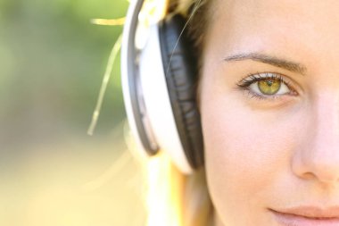 Ön manzara, kulaklık takan güzel bir kadın sana bakıyor.