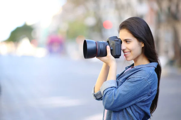 一个快乐的摄影师在街上拍照的侧景肖像 — 图库照片