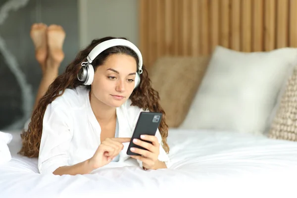 Жінка Навушниками Ліжку Дивиться Медіа Телефону Лежить Ліжку Кімнаті — стокове фото