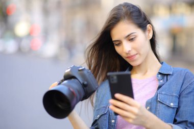 Fotoğrafçı sokakta telefon kamerası kullanıyor.