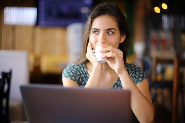 Distracted Woman Using Laptop Drinking Coffee Shop Looking Side — Stock Photo, Image