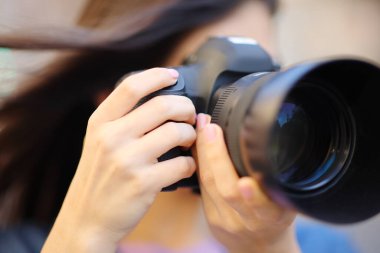 Dış mekanda refleks kamerayla fotoğraf çeken bir fotoğrafçıya yaklaş.