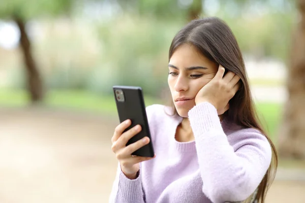 Bored Woman Checks Smart Phone Sitting Park — Stock Photo, Image