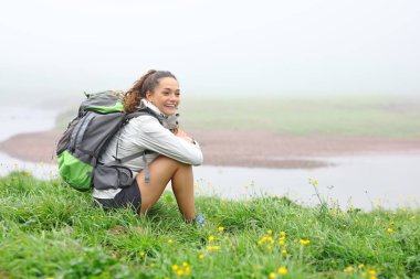 Yürüyüşçü sisli bir günde oturup doğada dinlenmeyi düşünüyor.