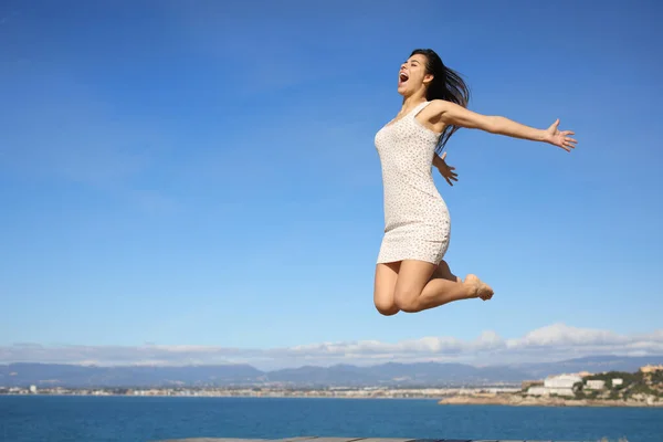 幸せな女性は夏休みを祝う海岸でジャンプ — ストック写真