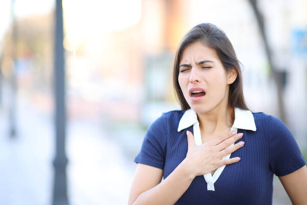 Stressed woman choking and complaining in the street