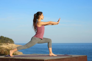 Plajda Tai Chi egzersizi yapan bir kadının tüm vücut profili.