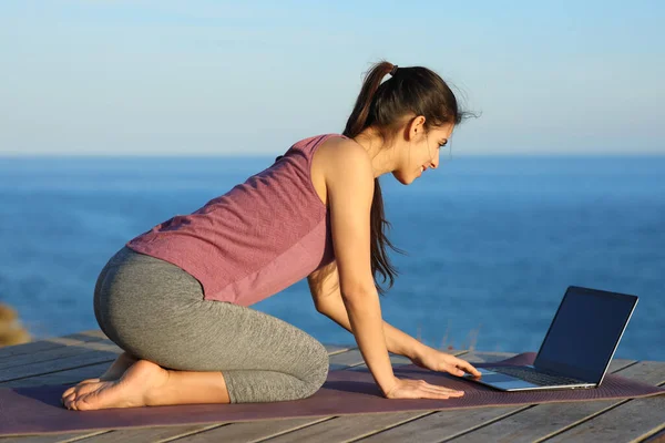 Kumsalda Yoga Egzersizleri Öğrenmek Için Dizüstü Bilgisayar Kullanan Sporcu Kadın — Stok fotoğraf