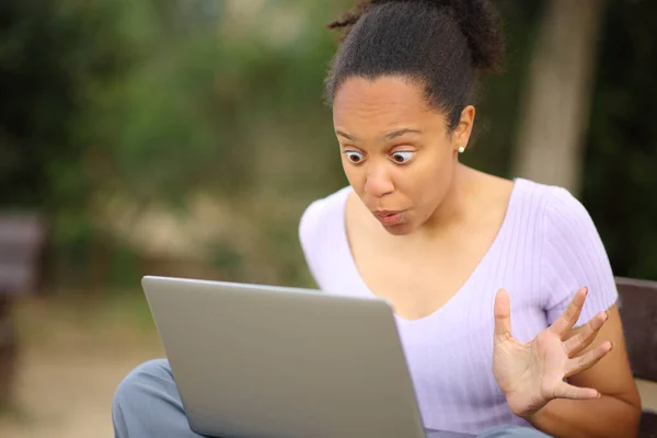 Überraschte Schwarze Frau Überprüft Laptop Inhalt Auf Einer Bank Einem — Stockfoto