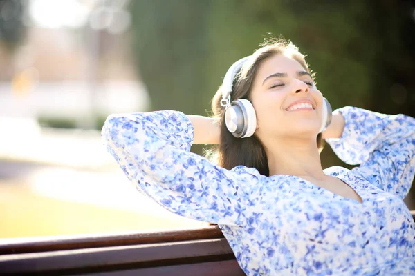 Parkta Bankta Oturmuş Kulaklıkla Müzik Dinleyen Mutlu Bir Kadın — Stok fotoğraf